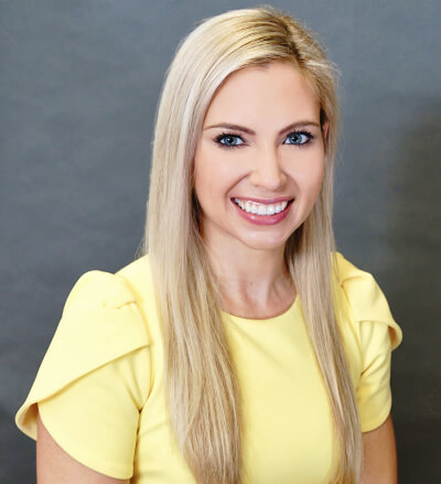 Smiling picture of Jennifer Murdock MD with yellow top