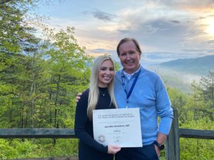 Dr Jennifer Murdock holding Americal Society of Ophthalmic Plastic and Reconstructive Surgery fellowship certificate along with Roger Dailey