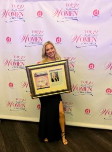 Dr Jennifer Murdock holding certificate frame of Top 30 influential women of Houston
