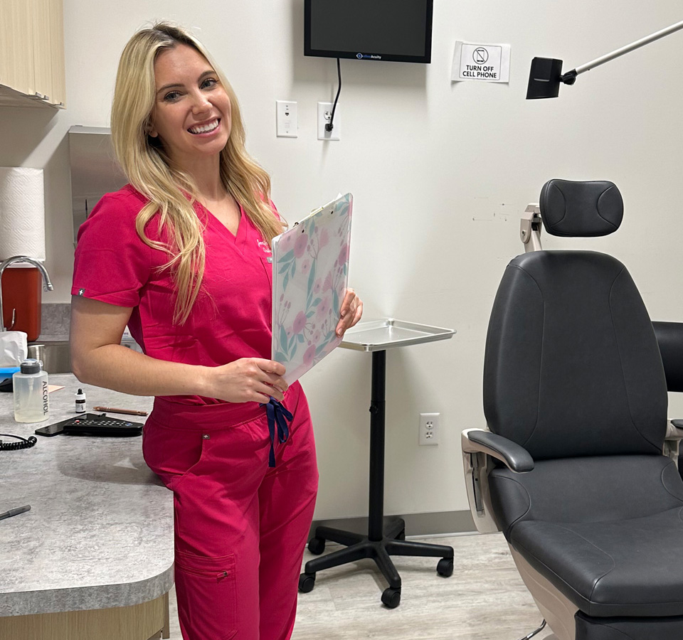 Dr. Murdock with pink color outfit in her clinic holding a writing pad