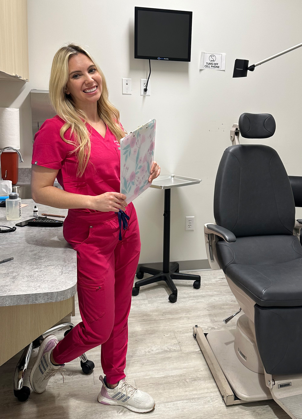 Dr. Murdock with pink color outfit in her clinic holding a writing pad