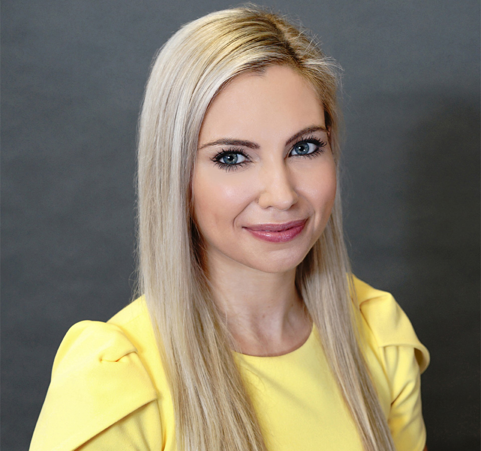 Dr. Murdock in a yellow outfit, posing for a professional portrait.